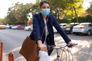 mulher andando de bicicleta com máscara