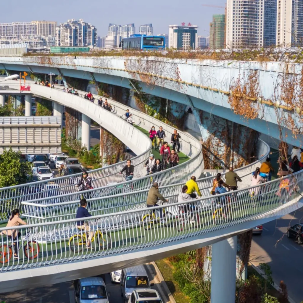 trecho da ciclovia elevada da china com pessoas utilizando  a estrutura nas suas bicicletas