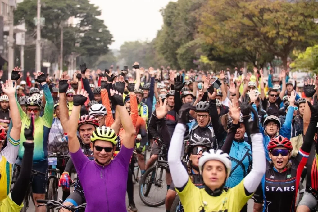 milhares de ciclistas com os braços para o alto